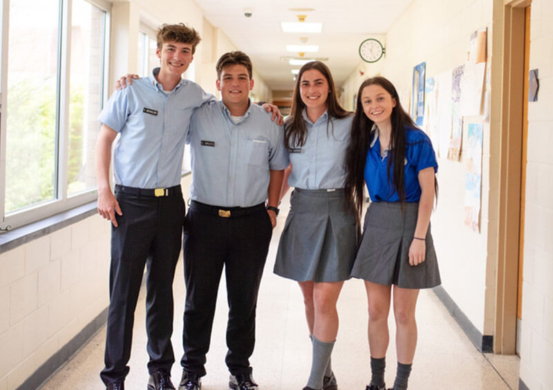 Four La Institute students pose in hallway